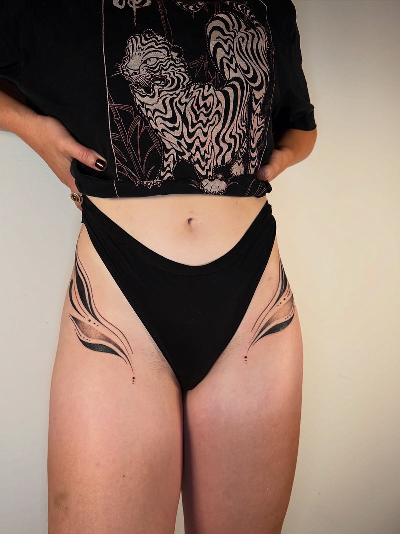 A person with ornamental hip tattoos