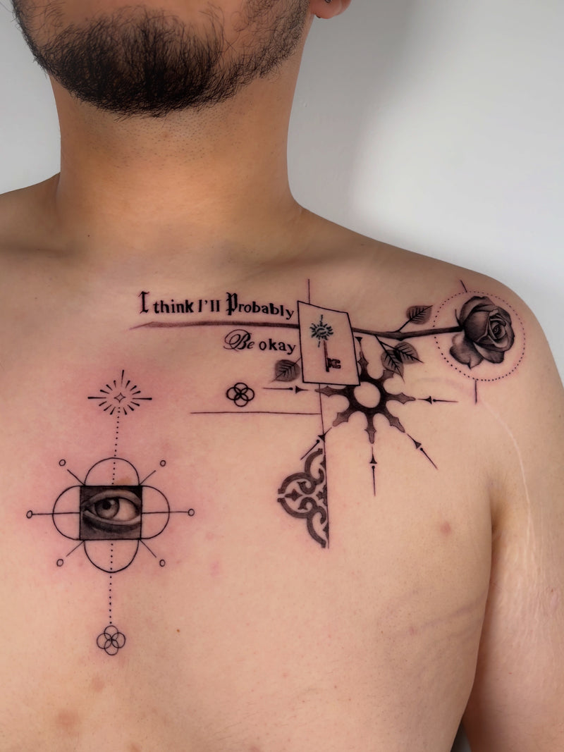 A close-up of a man's bare chest and shoulder showing a black ink tattoo design. The tattoo features an eye within a square, geometric line patterns, a rose, a key, and the text 'I think I'll probably be okay'.