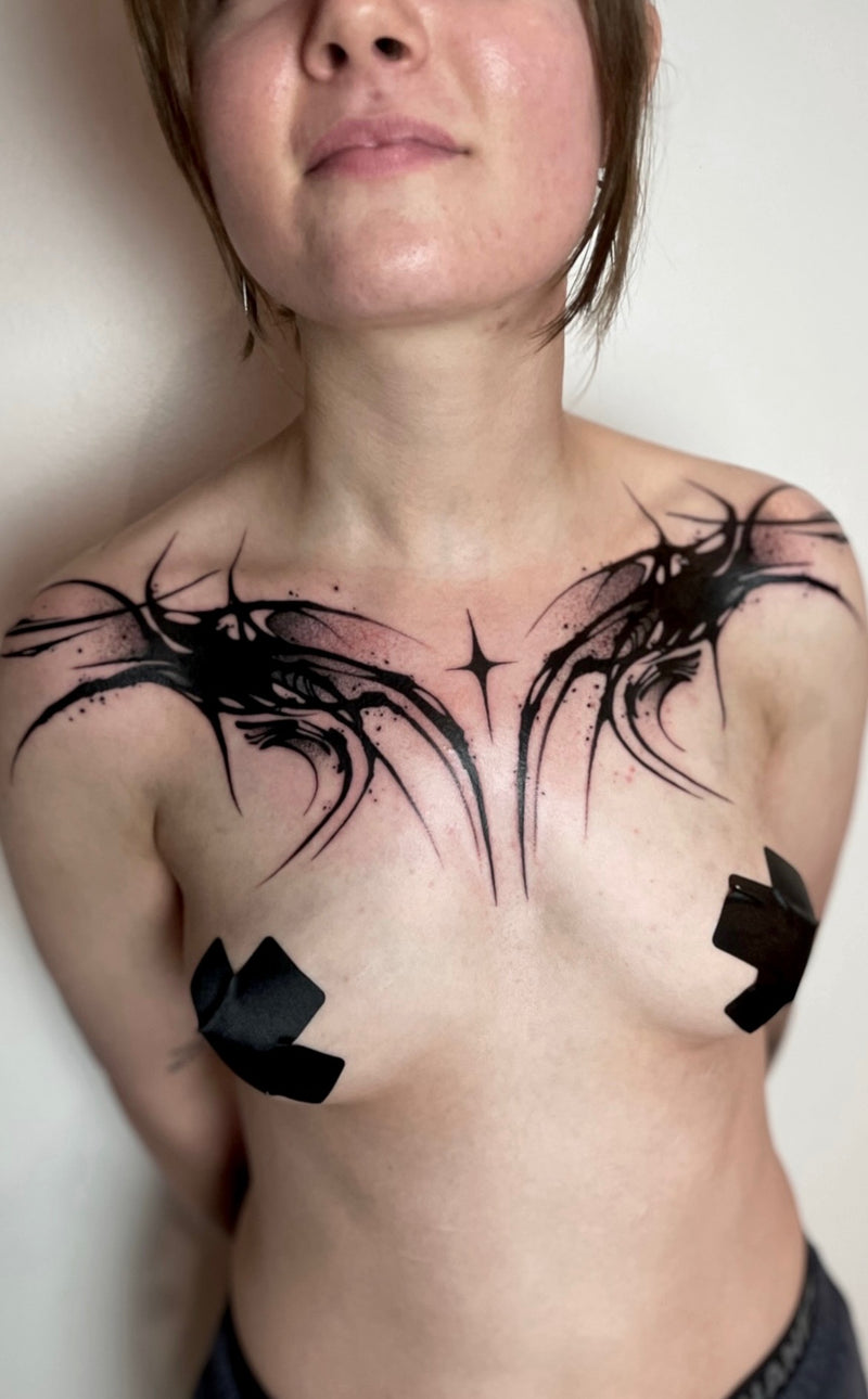 A black cybersigilsm tattoo on a person's chest.