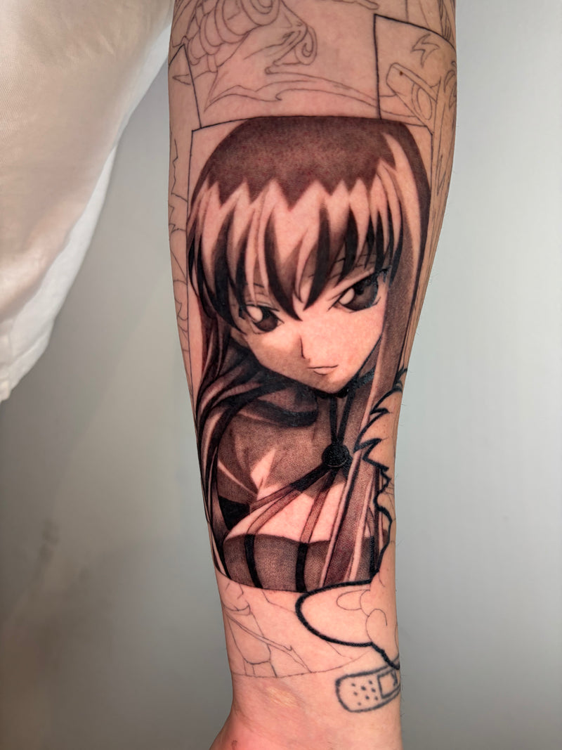 A close-up of a person's forearm featuring a detailed black and gray anime-style tattoo of a female character with long dark hair, with additional sketch designs visible around it.