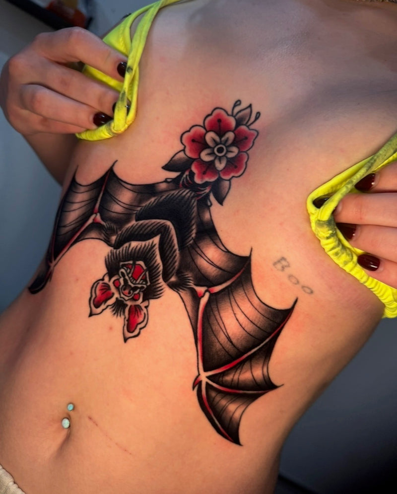 A close-up of a person's bat sternum tattoo