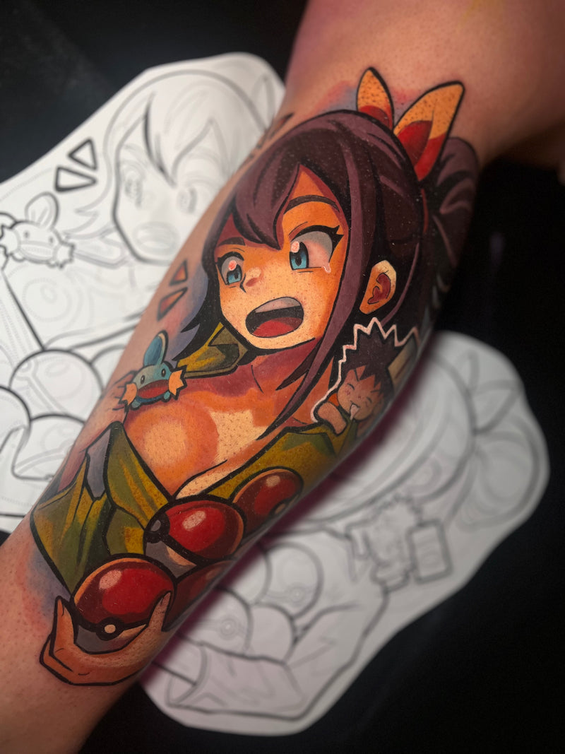 A colorful anime-style tattoo on a person's forearm, featuring a female character with dark hair, done by Kelsie